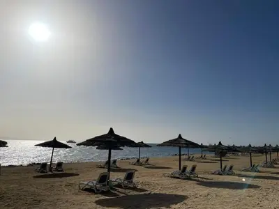 a group of chairs and umbrellas on a beach at Doplex for rent in the view 18 in Hurghada