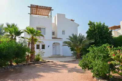 a white house with palm trees in front of it at 6 Bedroom Villa in El-Gouna 38 in Hurghada