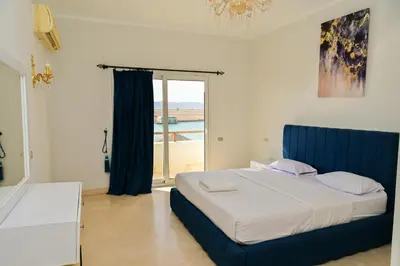 a bedroom with a bed with a blue headboard and a window at 6 Bedroom Villa in El-Gouna 38 in Hurghada
