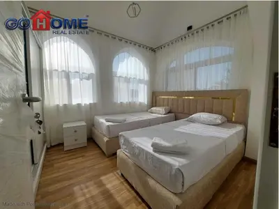 two beds in a bedroom with two windows at 2 Bedroom In Kafr El-Gouna in Hurghada