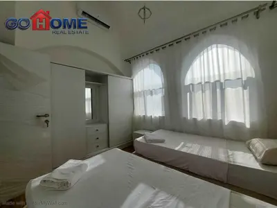 a white bedroom with two beds and a window at 2 Bedroom In Kafr El-Gouna in Hurghada
