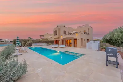 a villa with a swimming pool at sunset at Dream Beach House on Island 3BR Priv Pool Sabina El Gouna in Hurghada