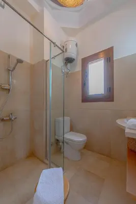 a bathroom with a toilet and a glass shower at Dream Beach House on Island 3BR Priv Pool Sabina El Gouna in Hurghada