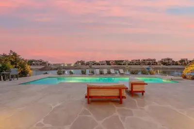 a swimming pool with two benches on a patio at Dream Beach House on Island 3BR Priv Pool Sabina El Gouna in Hurghada