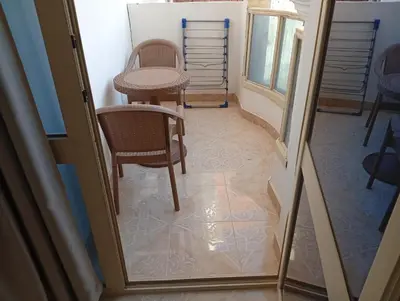a hallway with a table and chairs in a room at Lägenhet i villa med pool i Hurghada-Magawish in Hurghada