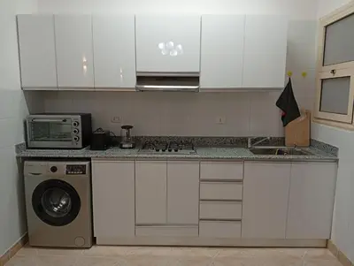 a kitchen with a stove top oven next to a microwave at Lägenhet i villa med pool i Hurghada-Magawish in Hurghada