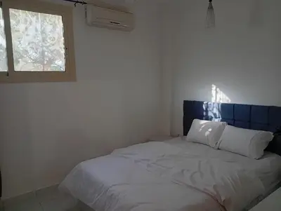 a bedroom with a bed with a blue headboard and a window at Lägenhet i villa med pool i Hurghada-Magawish in Hurghada