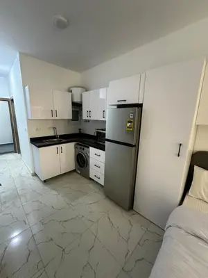 a small kitchen with white cabinets and a refrigerator at Wonderful sea view studio in Hurghada