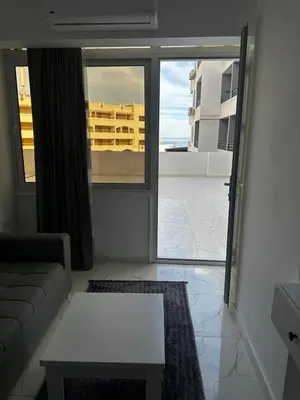 a living room with a couch and a view of a building at Wonderful sea view studio in Hurghada