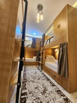 a room with two bunk beds and a rug at Hana Stay Hostel in Luxor