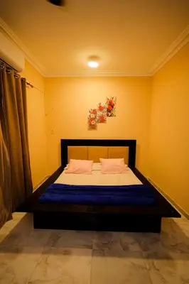 a bedroom with a bed in a room with yellow walls at Nile View House in Aswan