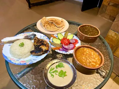 a glass table with plates of food and bowls of dips at Nile View House in Aswan