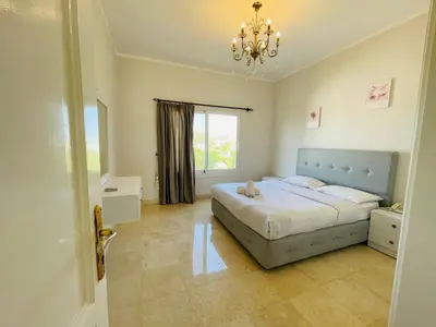 a bedroom with a bed and a chandelier at Luxury villa in gouna in Hurghada
