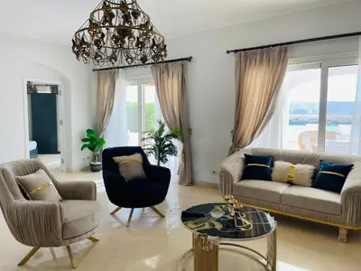a living room with a couch and chairs and a chandelier at Luxury villa in gouna in Hurghada