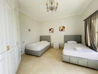 a bedroom with two beds and a chandelier at Luxury villa in gouna in Hurghada