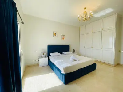 a bedroom with a blue bed and a chandelier at Luxury villa in gouna in El Gouna
