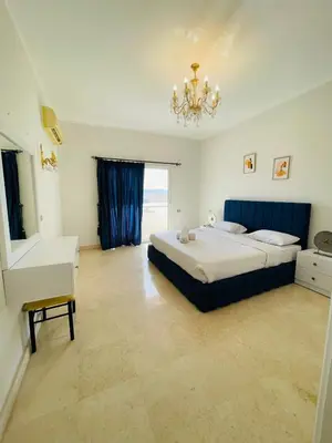 a large bedroom with a bed and a chandelier at Luxury villa in gouna in El Gouna