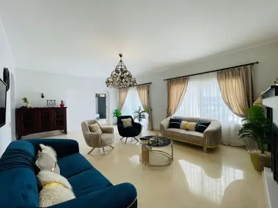 a living room with a dog laying on a blue couch at Luxury villa in gouna in El Gouna