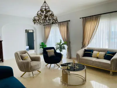 a living room with a couch and chairs and a chandelier at Luxury villa in gouna in El Gouna