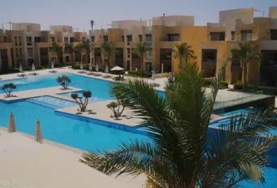 a resort with two pools with palm trees and buildings at 1 Bedroom In Mangroovy M1 -7B -011 in Hurghada