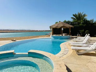 a swimming pool with lounge chairs and a gazebo at Luxury vill in gouna in Hurghada
