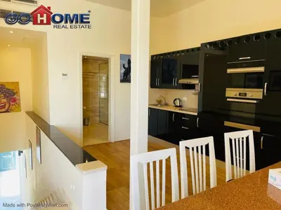 a kitchen with black cabinets and white appliances at Studio In Marina El Gouna in Hurghada