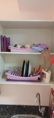 a kitchen shelf with dishes and utensils on it at Florenza Khamsin Hurghada in Hurghada