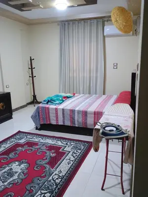 a bedroom with two beds and a rug at Families only in Al ‘Izbah wa al ‘Arab