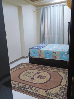 a bedroom with two beds and a rug on the floor at Families only in Al ‘Izbah wa al ‘Arab