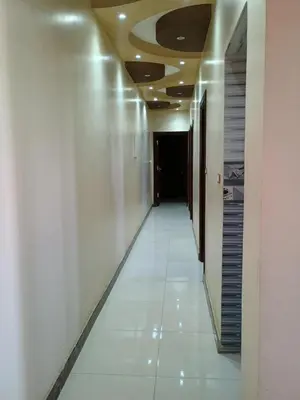 a hallway in a building with white walls and a ceiling at Families only in Al ‘Izbah wa al ‘Arab