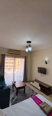 a bedroom with a bed and a couch and a tv at Florenza in Hurghada