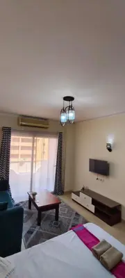 a bedroom with a bed and a couch and a tv at Florenza in Hurghada