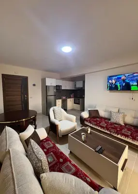a living room with couches and a tv on the wall at Tiba Gold in Hurghada