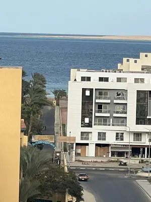 a large white building with the ocean in the background at Tiba Gold in Hurghada