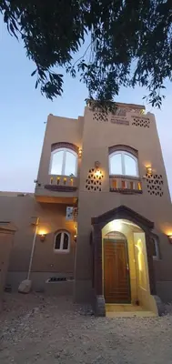 a large building with a door and windows on it at Mountain house in ‘Ezbet Abu Ḥabashi