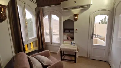 a living room with a couch and two windows at Mountain house in ‘Ezbet Abu Ḥabashi