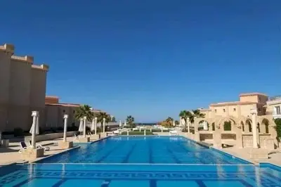 a large swimming pool with palm trees and buildings at Selena bay resort in Hurghada
