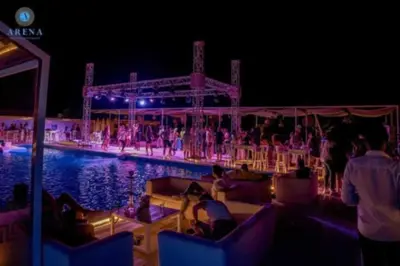 a group of people sitting around a pool at night at Selena bay resort in Hurghada