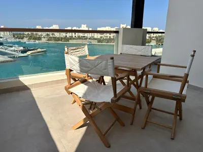 a wooden table and two chairs on a balcony at Fanadir Marina Vista in Hurghada