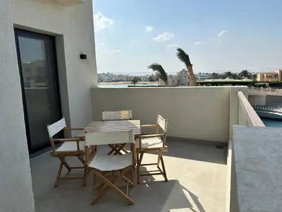 a patio with a table and chairs on a balcony at Fanadir Marina Vista in Hurghada