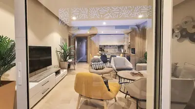 a living room with a yellow chair and a television at Stylish Gouna Mangroovy Retreat in Hurghada