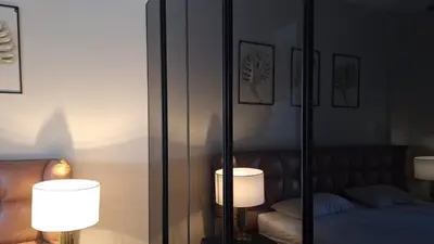 a bedroom with a mirror with a bed and two lamps at Stylish Gouna Mangroovy Retreat in Hurghada