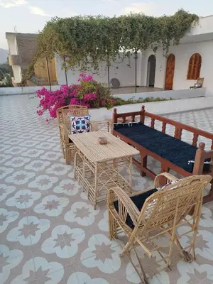 a patio with a table and chairs and a bench at Gabawy Garden in ‘Ezbet Abu Ḥabashi