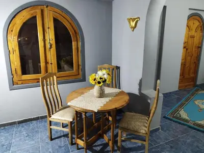 a dining room table with a vase of flowers on it at Gabawy Garden in ‘Ezbet Abu Ḥabashi