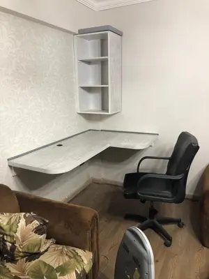a desk in the corner of a room with a chair at cozy penthouse in New Cairo in Kharga