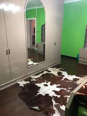a room with a cow rug on the floor and a mirror at cozy penthouse in New Cairo in Kharga