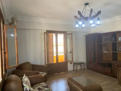 a living room with a couch and a chandelier at cozy penthouse in New Cairo in Kharga