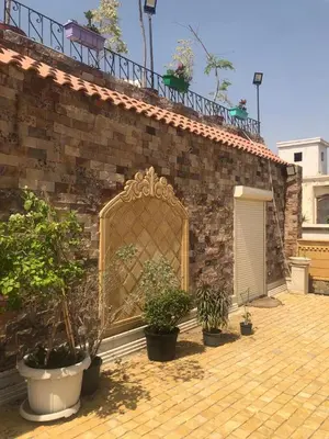 a brick building with a gate and potted plants on it at cozy penthouse in New Cairo in Kharga