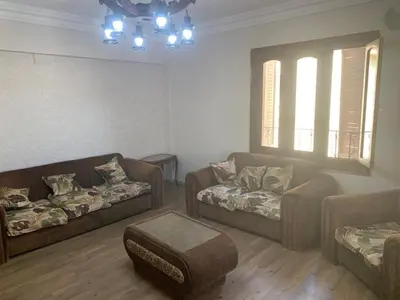 a living room with two couches and a ottoman at cozy penthouse in New Cairo in Kharga