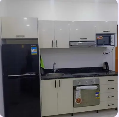 a kitchen with a black refrigerator and a sink at Selena bay resort in Hurghada